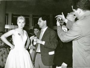 Sul set del film "La donna del giorno" - Regia Francesco Maselli, 1957 - Piano americano di Francesco Maselli che parla con Virna Lisi. L'attrice ha, appuntato sul vestito, il numero 14. Armando Nannuzzi, di spalle, misura la luce con un fotometro.