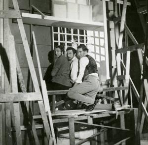 Sul set del film "Il dottor Antonio" - Regia Enrico Guazzoni, 1937 - Tre uomini, seduti su un trabattello di legno, di spalle, con i volti rivolti alla camera.