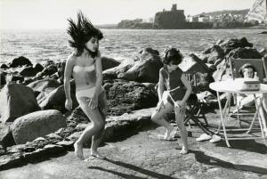 Scena del film "Don Giovanni in Sicilia" - Regia Alberto Lattuada, 1967 - Totale. Al mare Due ragazzine ballano accanto agli scogli. A destra, dietro un tavolino, si intravede una donna seduta su una sdraio.