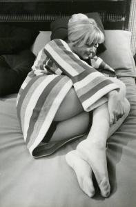 Scena del film "Don Giovanni in Sicilia" - Regia Alberto Lattuada, 1967 - Figura intera di Ewa Aulin stesa su un letto in posizione fetale. L'attrice tiene la testa sollevata dal cuscino con una mano e sorride.