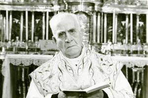 Scena del film "Don Giovanni in Sicilia" - Regia Alberto Lattuada, 1967 - Primo piano frontale di Ugo Attanasio, vestito da prete. L'attore, tiene il messale aperto all'altezza del petto.