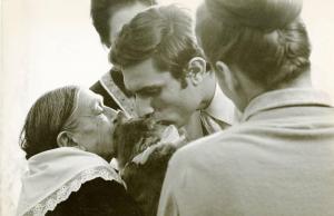 Scena del film "Don Giovanni in Sicilia" - Regia Alberto Lattuada, 1967 - Primo piano di profilo di Lando Buzzanca e di una donna anziana mentre baciano contemporaneamente un gatto sulla testa. Accanto a loro due donne.