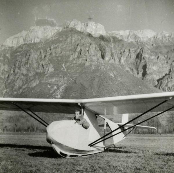 Sul set del film "L'ebbrezza del cielo" - Regia Giorgio Ferroni, 1940 - Un attore non identificato al posto di guida di un aliante con alle spalle una montagna.