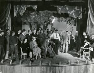 Sul set del film "I due misantropi" - Regia Amleto Palermi, 1937 - Attori e operatori di ripresa non identificati sul set. Seduto al centro si riconosce il regista Amleto Palermi.