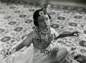 Scena del film "Le due tigri" - Regia Giorgio Candido Simonelli, 1941- Delia Cancelotti, vestita con abiti della tradizione indù, siede a terra a braccia aperte.