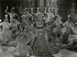 Scena del film "Le due tigri" - Regia Giorgio Candido Simonelli, 1941 - Totale di Alanova al centro, Delia Cancellotti sulla sinistra e attrici non identificate alle loro spalle che danzano.