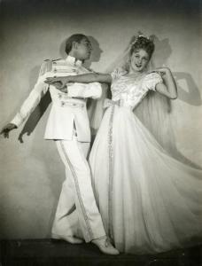 Scena del film "È bello qualche volta andare a piedi" - Regia Michele Galdieri, 1941 - Figure intere di Harry Feist, a sinistra, e Delia Lodi, a destra, in abiti eleganti e in posa di danza.