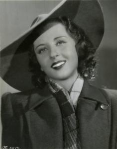 Scena del film "È caduta una donna" - Regia Alfredo Guarini, 1941 - Primo piano di Carla Martinelli con soprabito e cappello a tesa larga mentre guarda davanti a sé.
