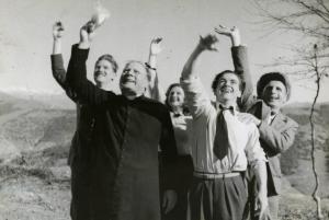 Scena del film "L'ebbrezza del cielo" - Regia Giorgio Ferroni, 1940 - Cinque attori rivolgono lo sguardo e le braccia verso l'alto in segno di saluto. Tra di essi, in primo piano, il prete agita verso l'alto un fazzoletto.