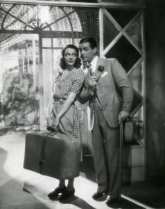 Scena del film "Ecco la felicità!" - Regia Marcel L'Herbier, 1940 - A sinistra, Jacqueline Delubac regge una valigia e osserva Ramon Novarro, a destra.