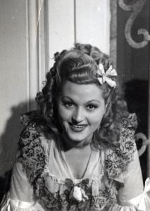 Sul set del film "Elisir d'amore" - Regia Amleto Palermi, 1941 - Mezza figura di Livia Minelli che, in posa, guarda dritto davanti a sé.