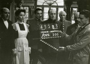Sul set del film "La fabbrica dell'imprevisto" - Regia Jacopo Comin, 1942 - Sei attori non identificati aspettato il ciak. A destra un operatore.