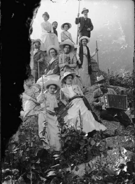 Alta Val Brembana. Ritratto di un gruppo di gitanti in montagna accompagnati da suonatore di fisarmonica