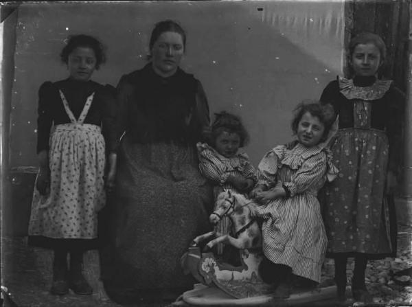 Val Brembana. Ritratto di donna con quattro figlie e un cavallino a dondolo