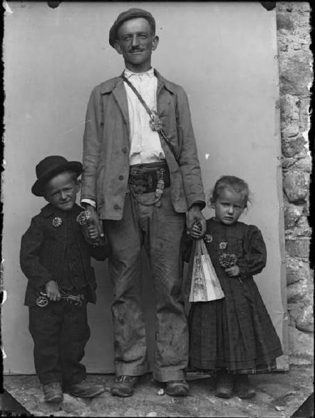 Val Brembana. Ritratto di un uomo che indossa la cintura dei bocciofili e due bambini