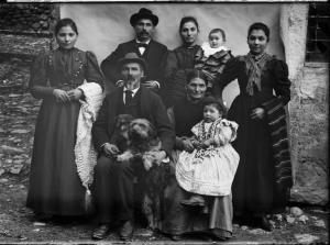 Val Brembana. Ritratto di famiglia con due cani e casa rurale sullo sfondo