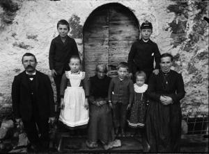 Val Brembana. Ritratto di famiglia con ragazzo in divisa davanti a una casa rurale