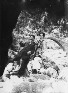Val Brembana. Ritratto di una famiglia in gita presso un torrente con ponte sullo sfondo