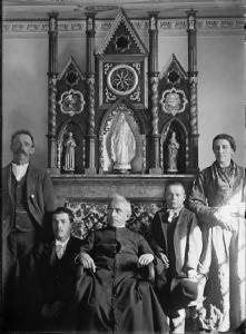 Cusio. Ritratto di famiglia con prete e, sullo sfondo, trittico devozionale
