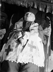 Val Brembana. Esposizione funebre della salma di un prete con crocifisso e rosario tra le mani