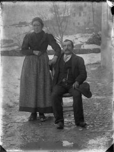 Val Brembana. Ritratto di una coppia di coniugi in una strada di paese con paesaggio innevato sullo sfondo