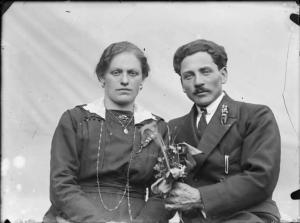 Val Brembana. Ritratto di una coppia di giovani sposi: l'uomo offre un bouquet alla donna