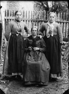 Val Brembana. Ritratto di una donna anziana con le figlie e la corona del rosario in mano