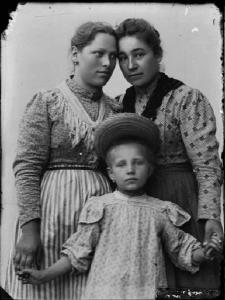 Val Brembana. Ritratto di due donne con una bambina con cappello di paglia in testa