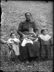 Val Brembana. Ritratto di una madre con i figli piccoli in un campo
