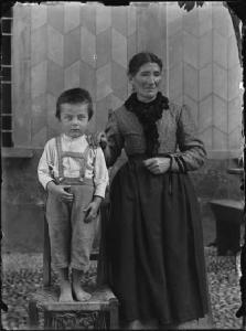 Val Brembana. Ritratto di donna con un bambino in piedi su una sedia