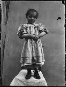 Val Brembana. Ritratto di bambina in piedi su sedia