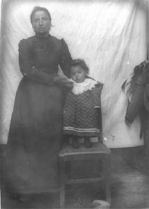 Val Brembana. Ritratto di donna con bambino piccolo in piedi su una sedia