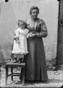 Val Brembana. Ritratto di donna con bambina in piedi su una sedia