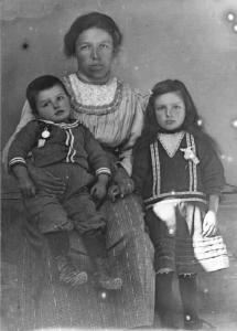 Val Brembana. Ritratto di donna con due bambini che hanno medaglie appuntate al petto