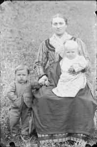 Val Brembana. Ritratto di donna con due bambini in un prato