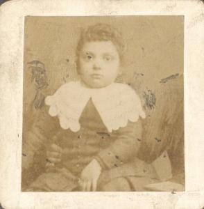 Ritratto di bambino seduto con colletto bianco