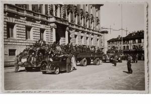 Fotografia di una colonna di partigiani in piazza Trento Trieste a Monza davanti al Municipio