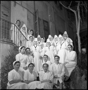 Ritratto di gruppo femminile - Infermiere e religiose lungo una scalinata esterna - Pavia - Piazza XXV maggio - Casa di cura «E. Morelli»