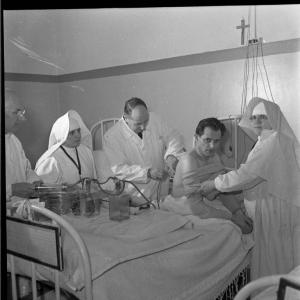 Pavia - Piazza XXV maggio - Casa di cura «E. Morelli» - Paziente sottoposto ad una visita medica - Due infermiere religiose assistono il medico