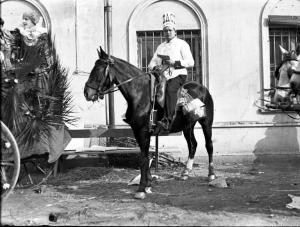 Ritratto maschile - Uomo in costume a cavallo - Garlasco - Festa del Carnevale - Scorcio di un carro allegorico di Carnevale a sinistra