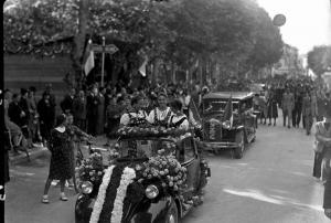 Salice Terme - Festa dell'uva - Sfilata di automobili la prima addobbata con fiori e con tre giovani donne in abiti tradizionali - Folla radunata ai lati del viale alberato