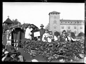 Pavia - Piazza Castello - 3° Festa nazionale dell'uva - Carro decorato con tralci di vite e grappoli d'uva e gruppo di persone in abiti tradizionali - Castello visconteo, scorcio sud occidentale, sullo sfondo