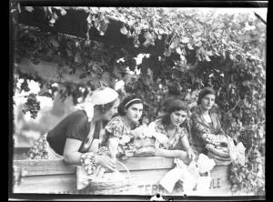Ritratto di gruppo femminile - Quattro donne in abiti tradizionali con foulard sul capo e cesti di vimini in mano - Carro addobbato con tralci di vite e grappoli d'uva - Pavia - 3° Festa nazionale dell'uva