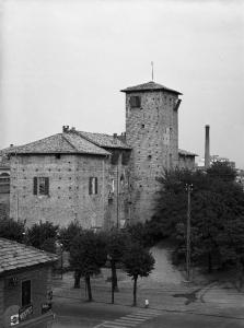 Voghera - Veduta del torrione del Castello visconteo - Edificio con cartelli pubblicitari a sinistra - Alberi