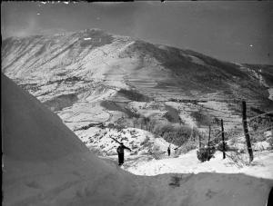 Cima Colletta - Panorama innevato - Uomo con sci sulle spalle percorre un sentiero in salita