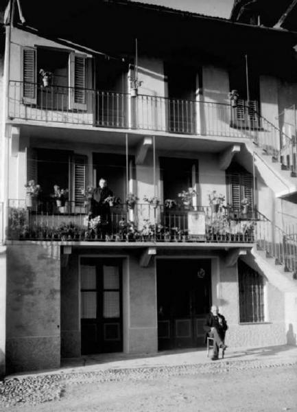Cogno - Casa Chierolini - Donna al balcone e uomo seduto