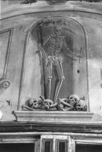 San Gervasio di Teglio. Edicola dell'ossario. Affresco raffigurante uno scheletro con teschi.