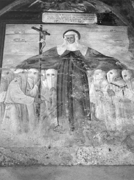 Cipriano Valorsa e aiuti. Affresco datato 1563 raffigurante Santa Marta, patrona della Confraternita, e i Disciplini accolti sotto il suo manto, vestiti di bianco e incappucciati.