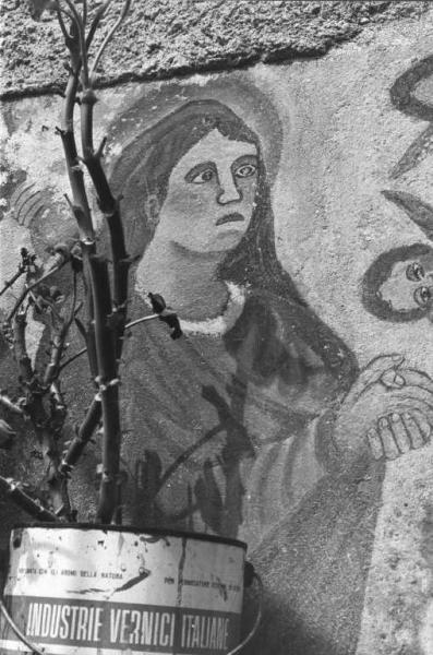 Particolare di pittura murale raffigurante una santa in preghiera.