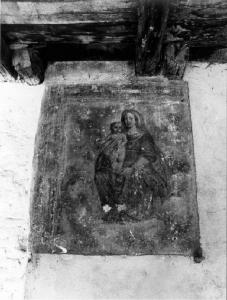 Pittura a fresco raffigurante Madonna con bambino sotto un portico di cascina.